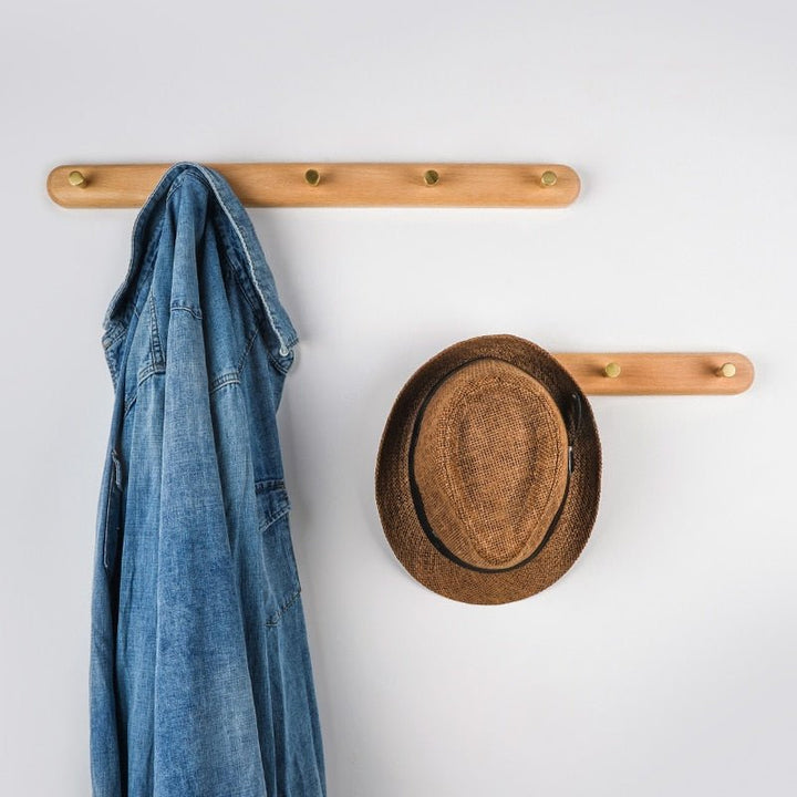 Porte-manteau en noyer noir et laiton, parfait pour une décoration d'entrée moderne et chic.