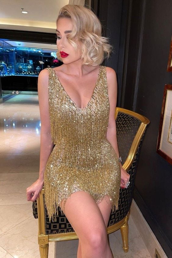 Robe de soirée femme à franges, coupe ajustée, décolleté en V, tissu scintillant, look glamour et moderne.