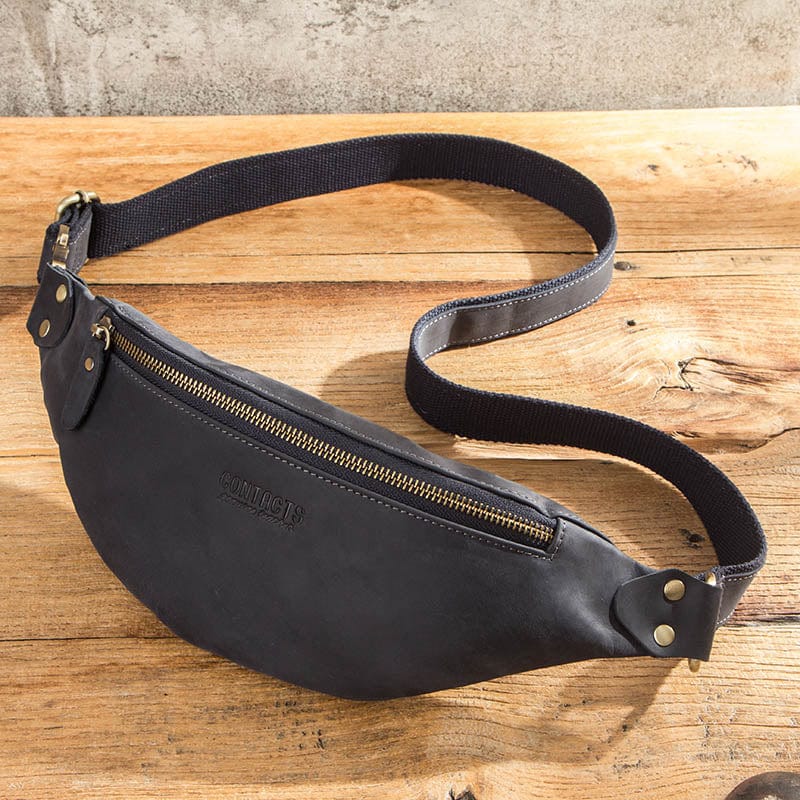 Homme moderne portant un sac banane en cuir noir à la taille, accessoire tendance pour un look décontracté.