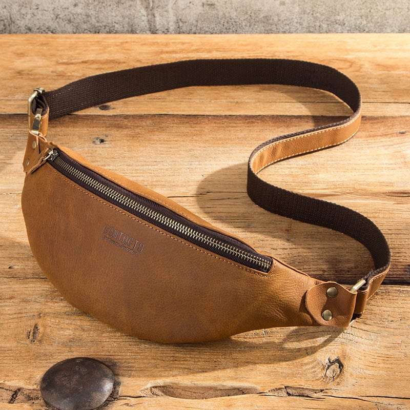 Détail du cuir pleine fleur d'un sac banane homme, finitions soignées, maroquinerie de qualité supérieure.