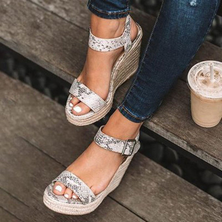 Sandales compensées femme avec bride réglable et boucle. Ces nu-pieds élégants sont parfaits pour un look estival.