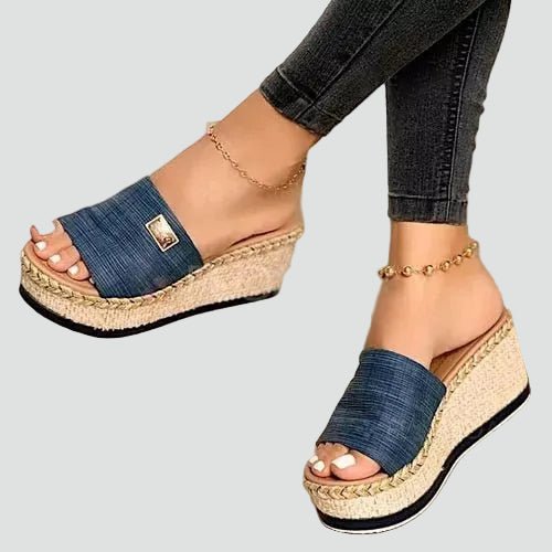 Femme portant des sandales compensées orthopédiques. Confort estival inégalé pour une marche aisée et stylée.