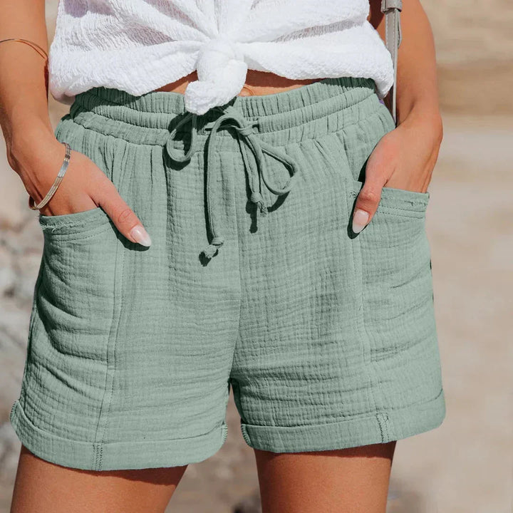Femme portant un short d'été décontracté et léger, taille élastiquée. Vêtement confortable pour la saison estivale.