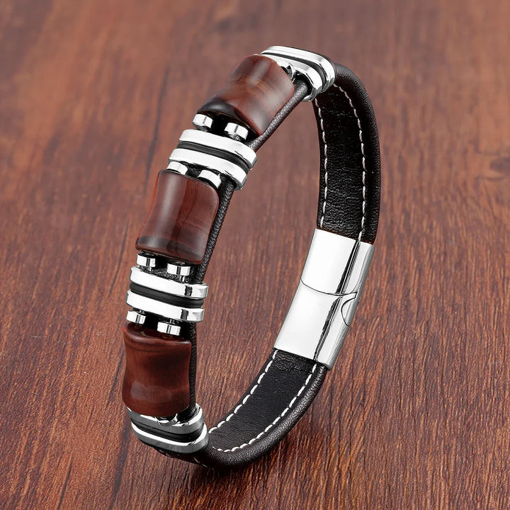Gros plan du bracelet unisexe: cuir marron et perles d'œil-de-tigre polies. Détail d'un bijou robuste.
