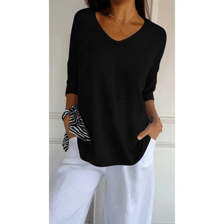 Élégant top femme à col V, manches 3/4. Idéal pour une tenue de mi-saison confortable et tendance.