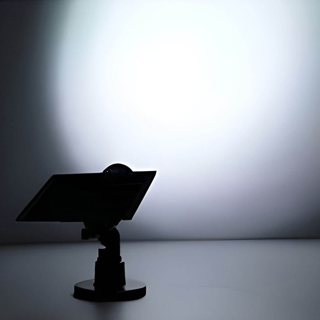 Spot LED solaire extérieur diffusant une lumière RGB colorée dans un paysage nocturne.