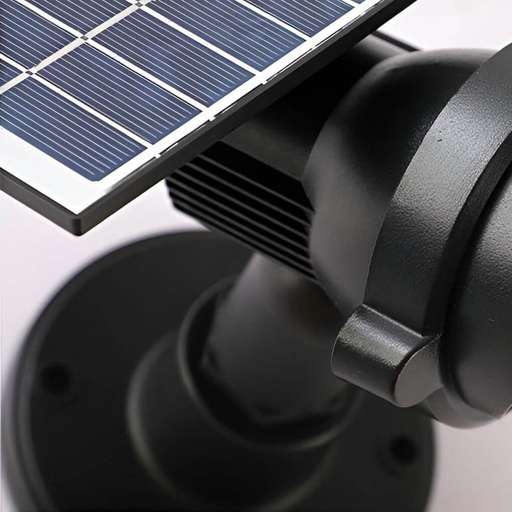 Ambiance chaleureuse: spot solaire LED blanc chaud mettant en valeur un arbuste du jardin la nuit.